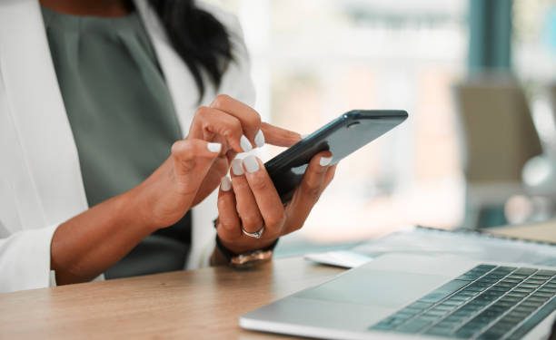 Phone, office and business woman networking on social media, the internet or a mobile app. Technology, corporate and professional company leader browsing on a mobile device in her modern workplace.